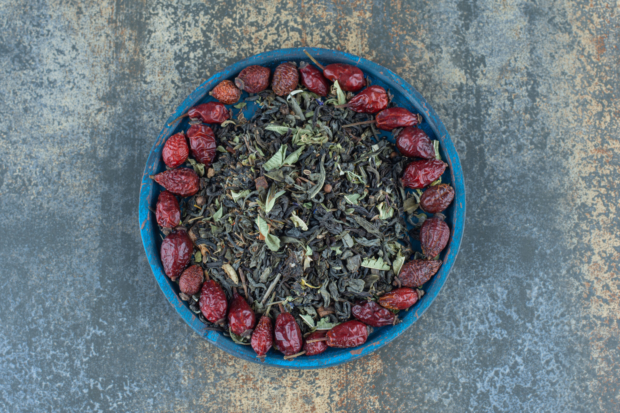 dried-rosehips-tea-leaves-blue-plate