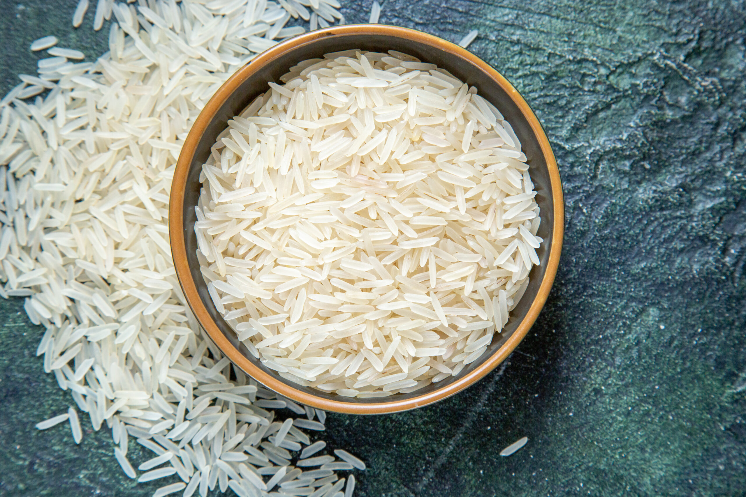 top-view-raw-rice-inside-plate-dark-desk